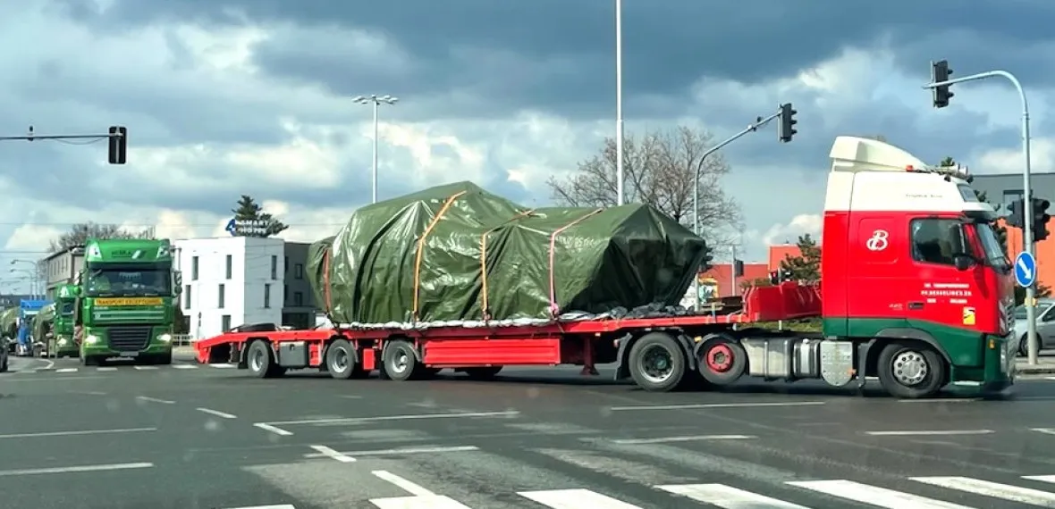 Kolona se zakrytou vojenskou technikou projíždí Olomoucí. Pod plachtou jsou s největší pravděpodobností zakryté samohybné houfnice 2S1 Gvozdika.